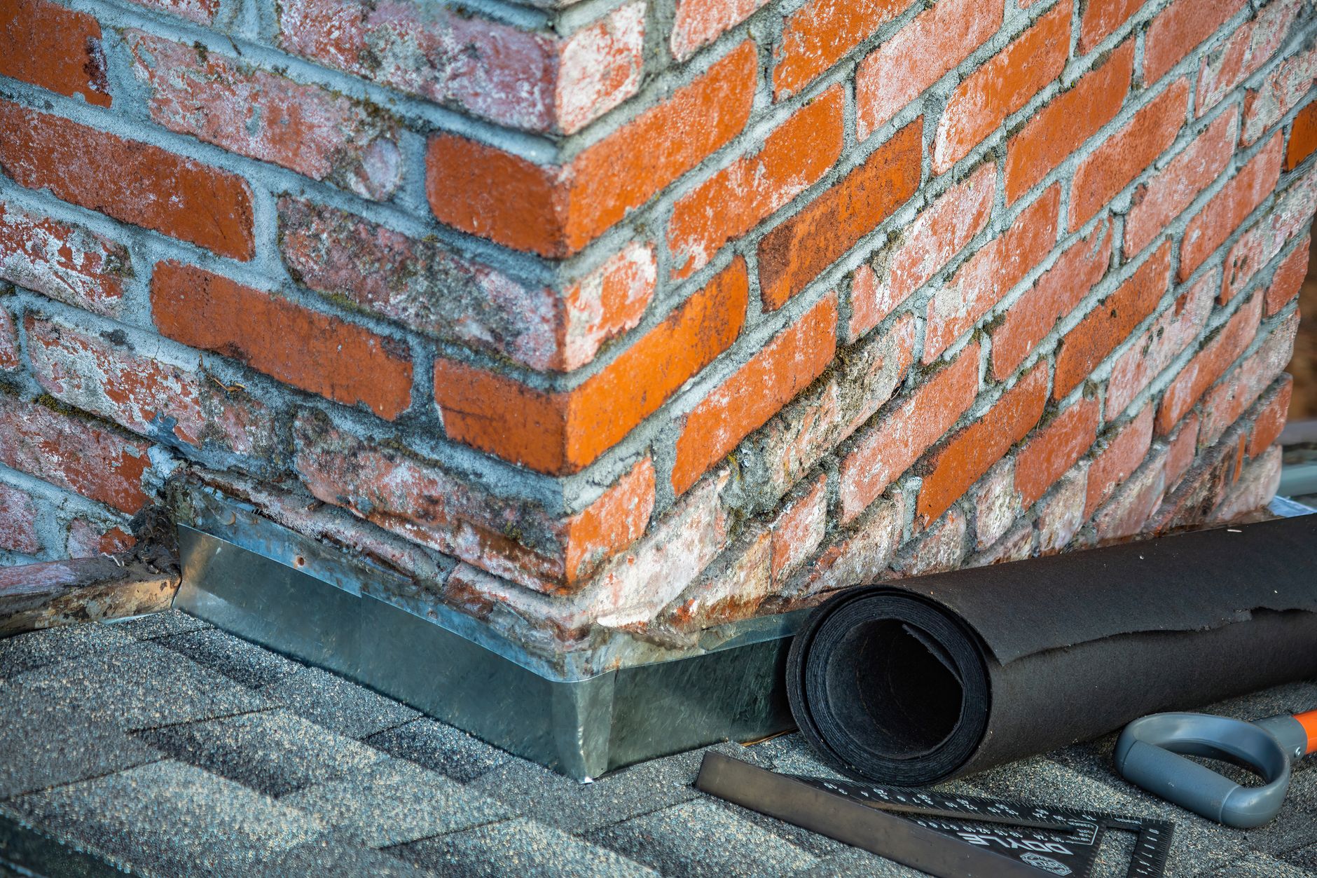 Close-up of masonry repair work on a residential brick chimney — signs you need chimney repair