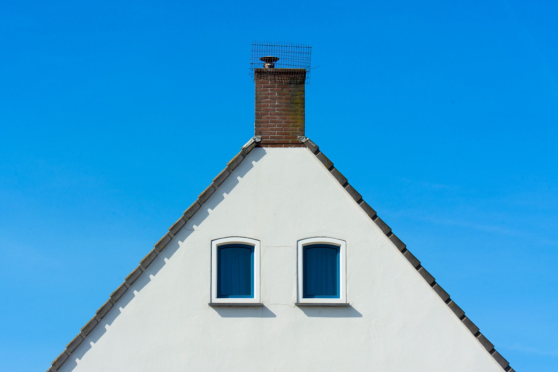 Rooftop showing chimney and surrounding shingles — chimney flashing leak causes and prevention